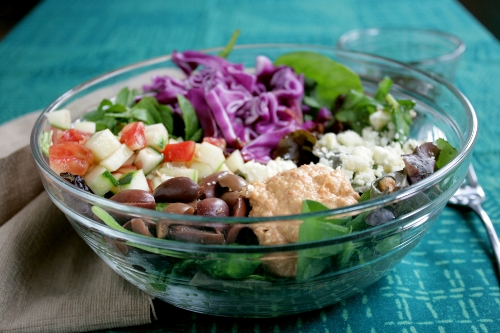 colorful mediterranean salad with hummus and harissa